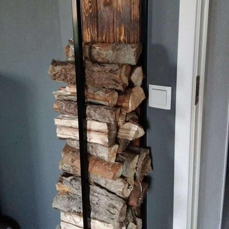 Ett vedställ som är upphängt på väggen, stålram i svart